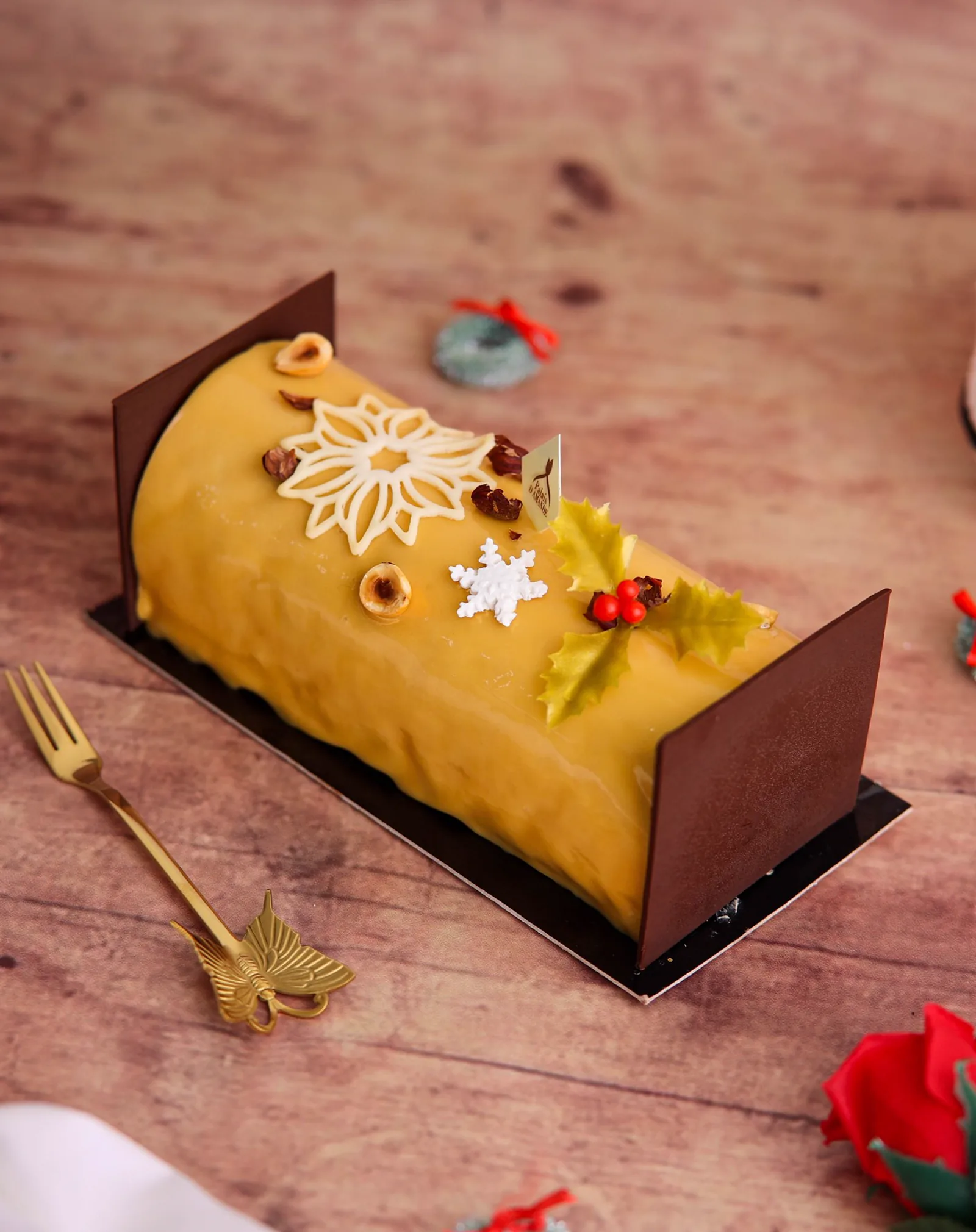 Bûche de Noël jaune, embouts chocolat, noisettes et houx