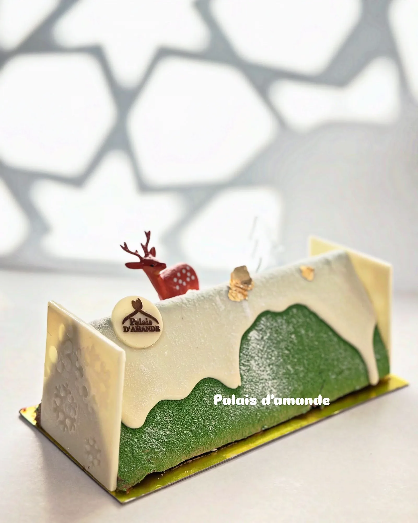 Bûche de Noël pistache et chocolat blanc, décor renne rouge