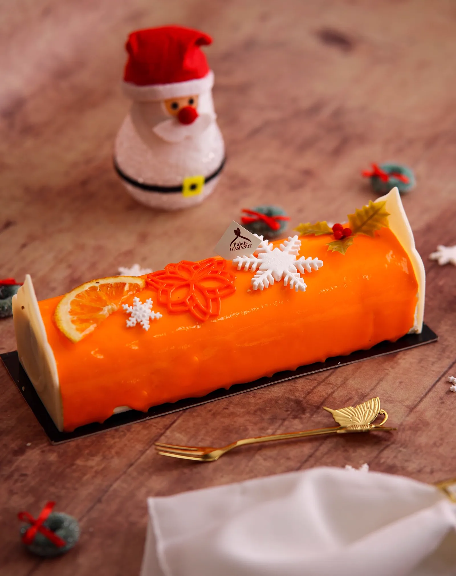 Bûche de Noël glaçage orange, tranche d'orange confite et flocons