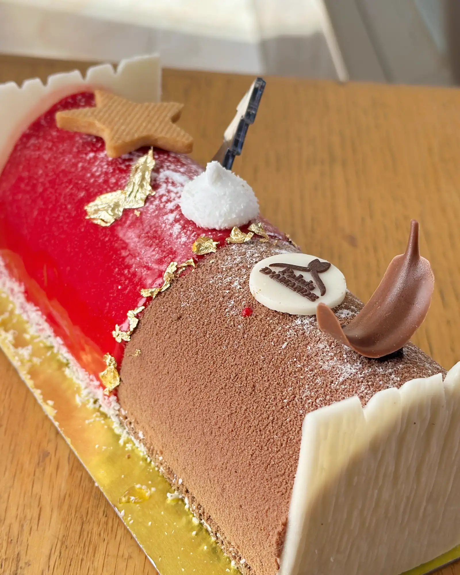 Bûche de Noël bicolore rouge et chocolat avec feuille d'or
