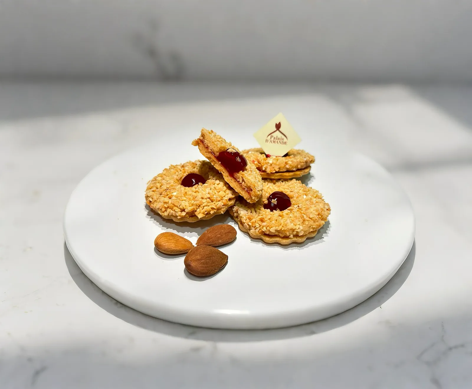 Sablés à la confiture sur assiette blanche avec amandes